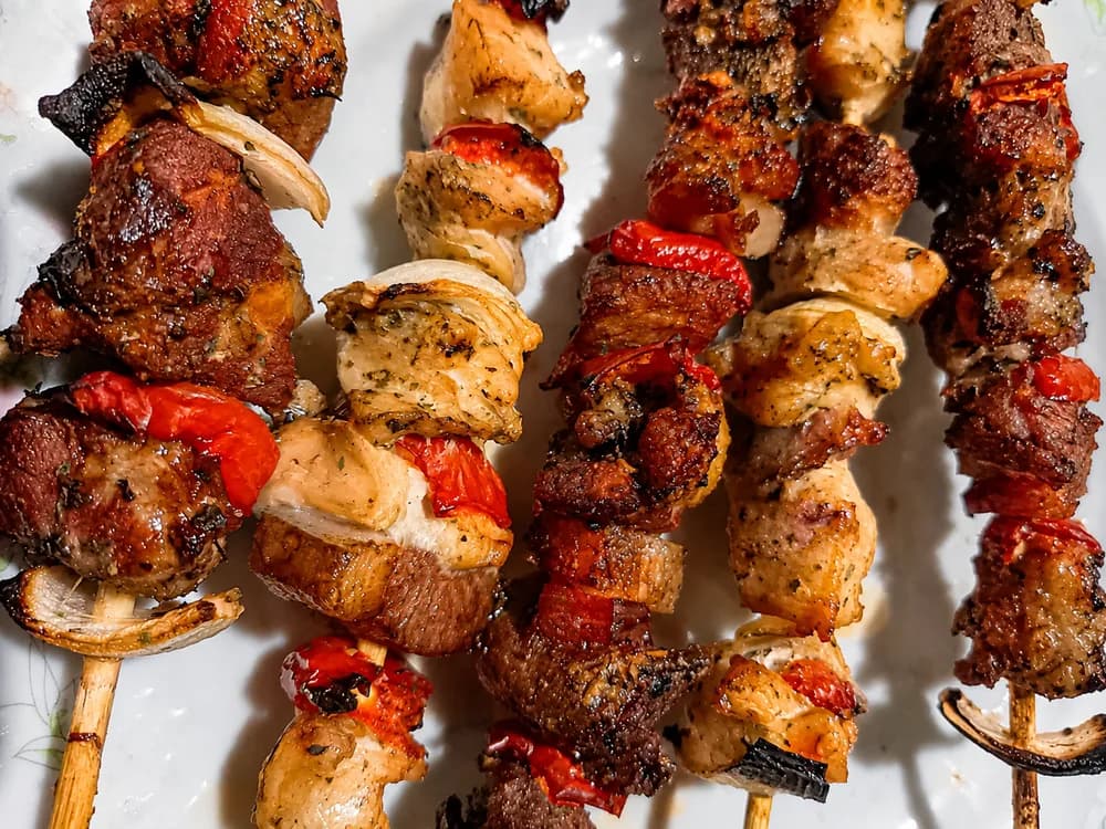 Brochetas de carne y pollo a la parrilla con morrón y cebolla de Antojos