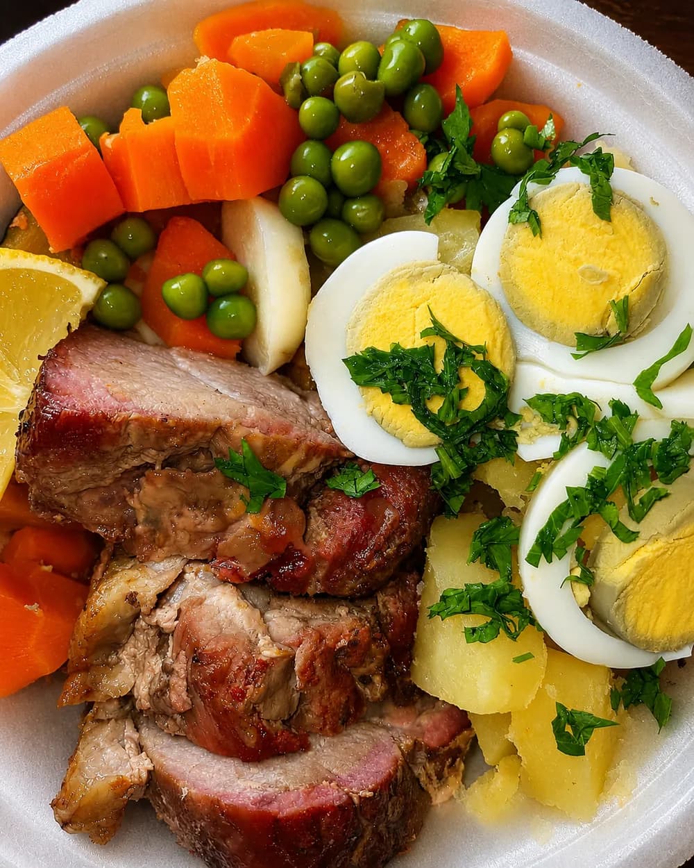 Ensalada con carne asada, zanahoria, arvejas, papa y huevo de Antojos